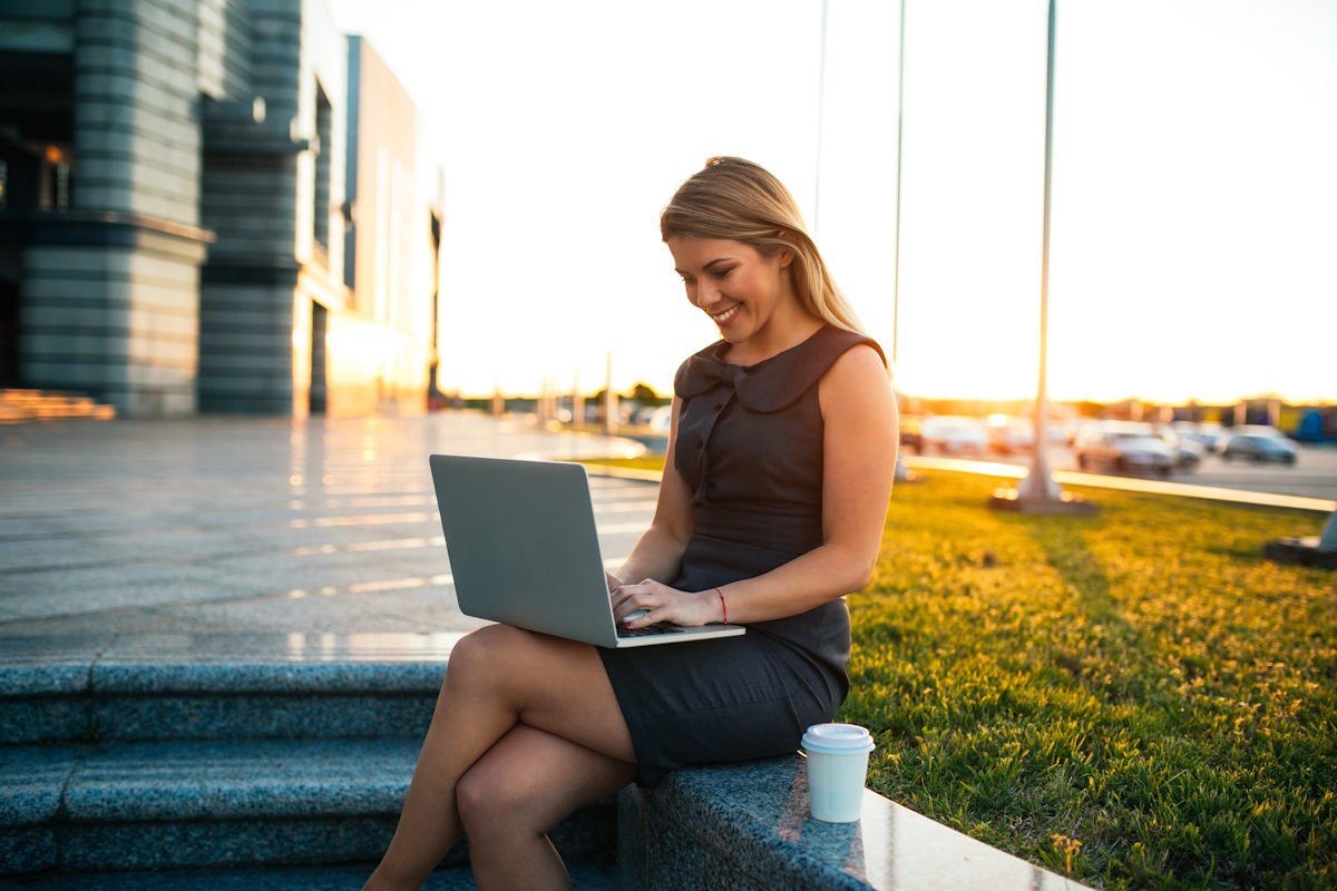 Two young professional women collaborating around a laptop